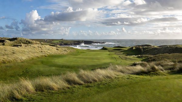 Atlantic links golf course with tall marram-grass dunes and ocean beyond under a broken sky